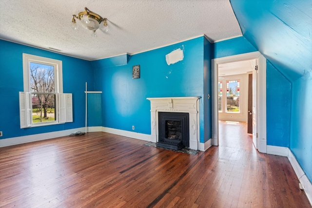 unfurnished living room with wood-type flooring, a textured ceiling, plenty of natural light, and lofted ceiling