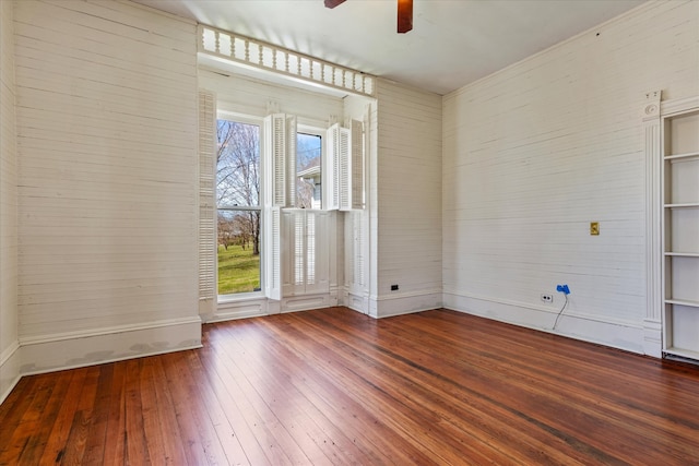 spare room with hardwood / wood-style floors, built in features, ceiling fan, and a healthy amount of sunlight