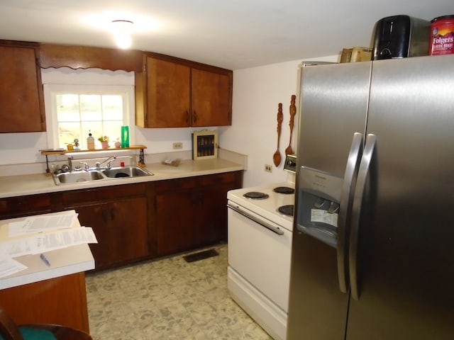 kitchen with stainless steel fridge, sink, light tile floors, and electric range