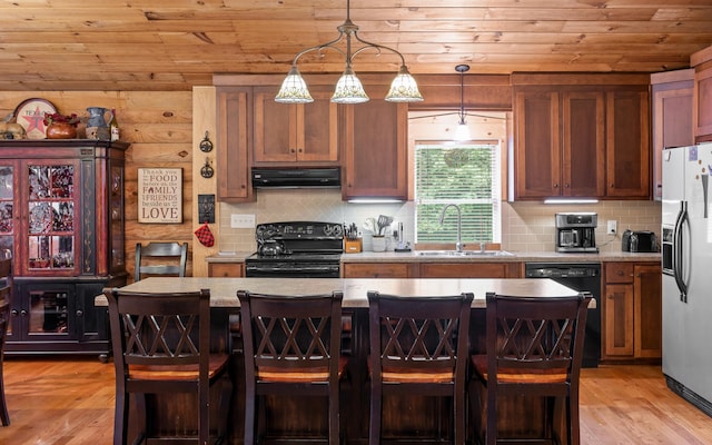 kitchen featuring wooden ceiling, exhaust hood, a sink, light countertops, and black appliances