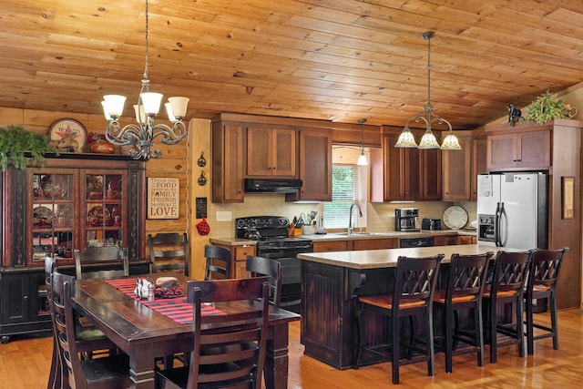 kitchen with white refrigerator with ice dispenser, lofted ceiling, a sink, under cabinet range hood, and black / electric stove