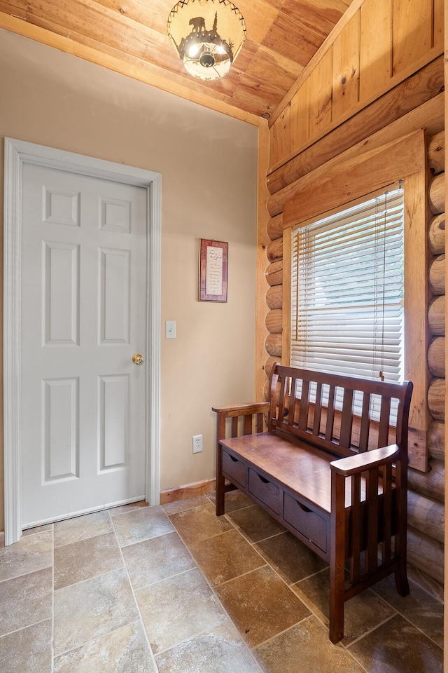 bedroom featuring wood ceiling, baseboards, and stone tile flooring