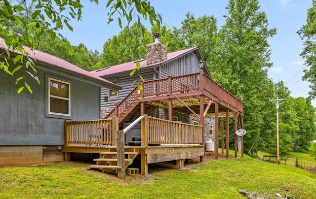 back of property featuring a yard, a chimney, stairway, metal roof, and a deck