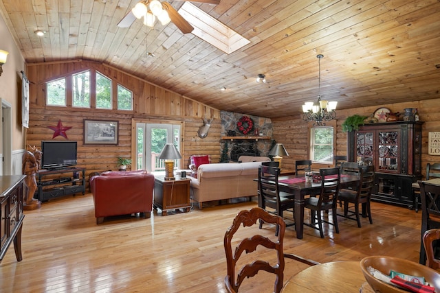 dining room with light wood finished floors, a skylight, wooden ceiling, log walls, and ceiling fan with notable chandelier