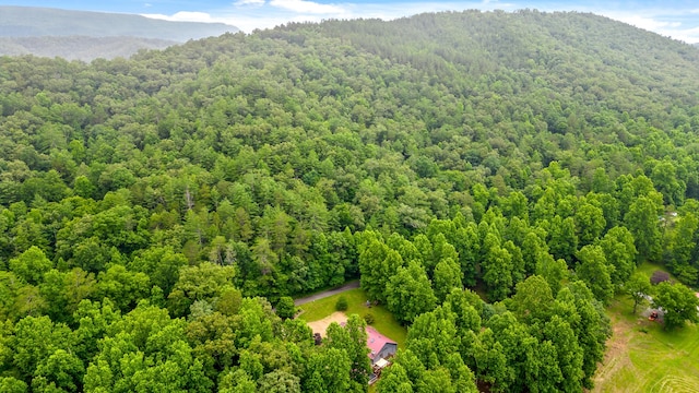 drone / aerial view with a wooded view and a mountain view