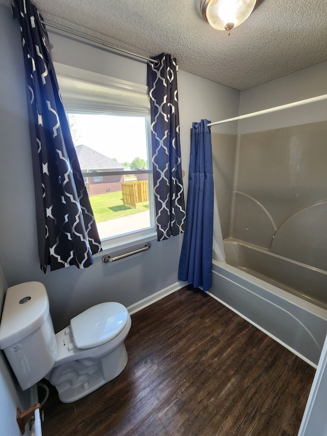 bathroom featuring a textured ceiling, toilet, hardwood / wood-style flooring, and shower / tub combo with curtain