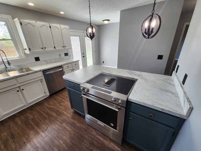 kitchen with hanging light fixtures, dark hardwood / wood-style floors, appliances with stainless steel finishes, sink, and white cabinets