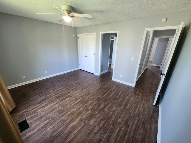 unfurnished bedroom with a textured ceiling, ceiling fan, and dark hardwood / wood-style flooring