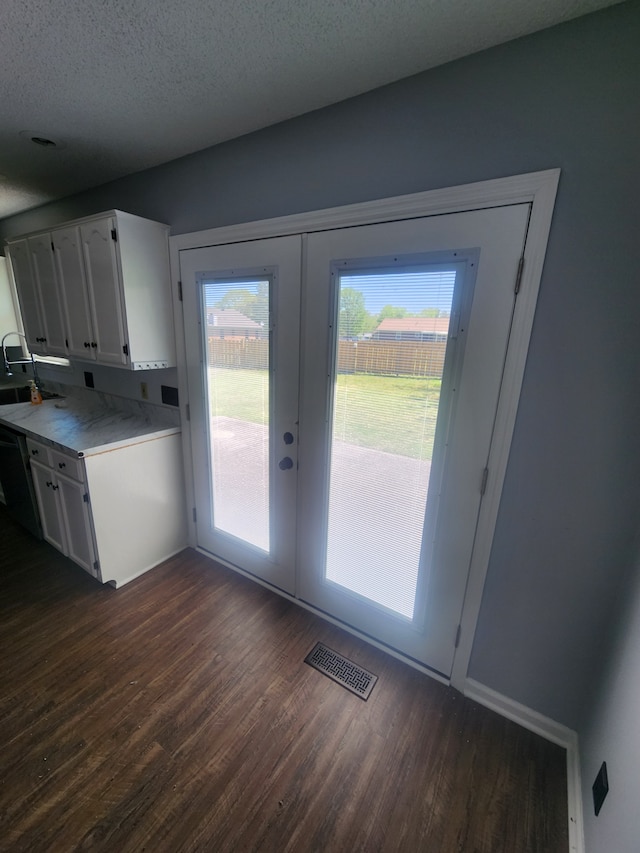 doorway to outside featuring a textured ceiling, french doors, and dark hardwood / wood-style flooring