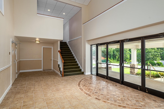 stairs featuring a high ceiling and french doors