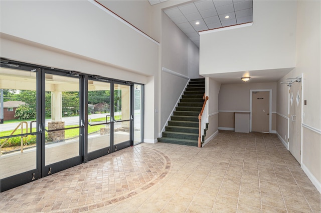 interior space featuring light tile flooring and a high ceiling