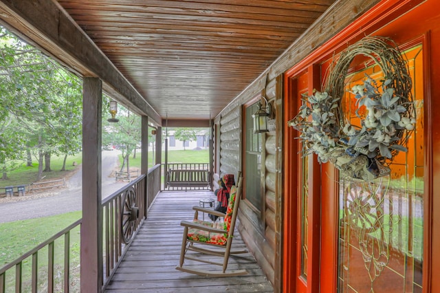 wooden terrace featuring a lawn