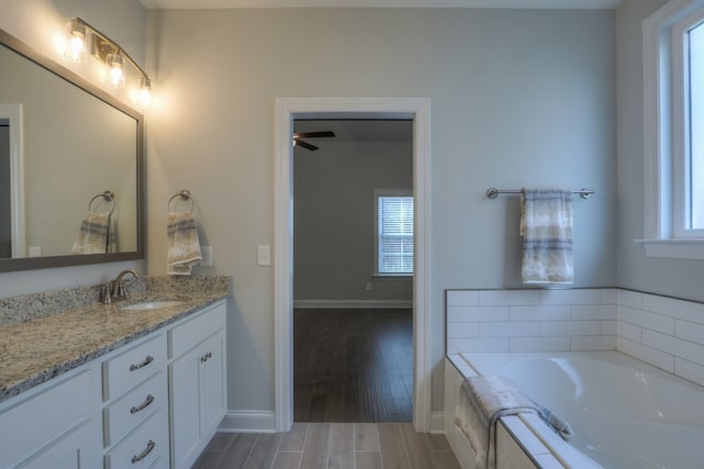 bathroom with wood-type flooring, ceiling fan, vanity, and plenty of natural light