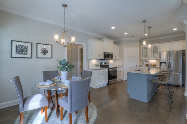 dining area with an inviting chandelier, crown molding, dark wood-type flooring, and sink