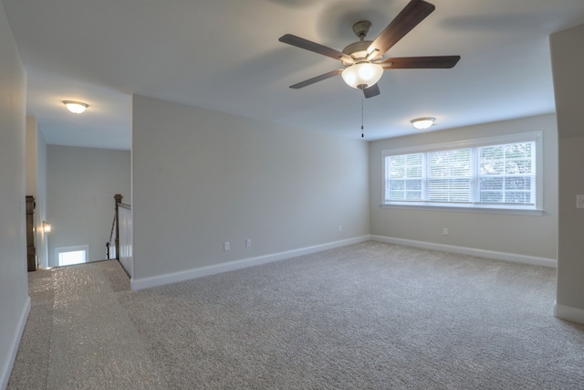 carpeted spare room with ceiling fan