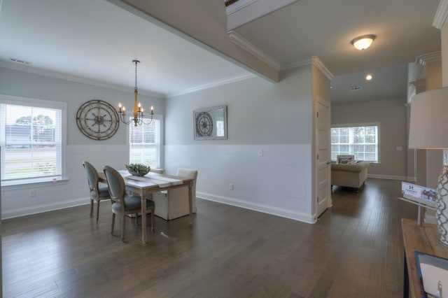 dining room with ornamental molding, an inviting chandelier, and dark hardwood / wood-style flooring