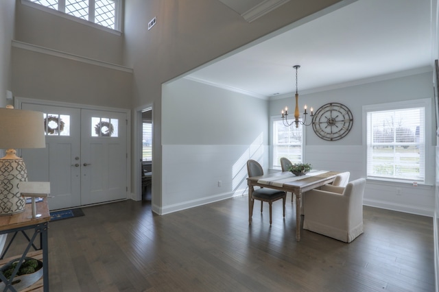 entryway featuring a notable chandelier, dark wood-type flooring, and ornamental molding