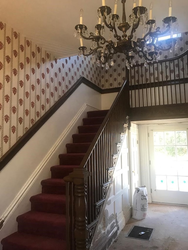 staircase featuring a towering ceiling and an inviting chandelier