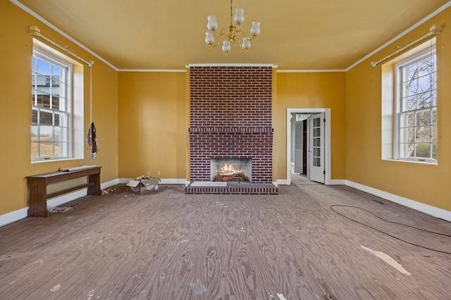 unfurnished living room with brick wall, plenty of natural light, ornamental molding, and a fireplace