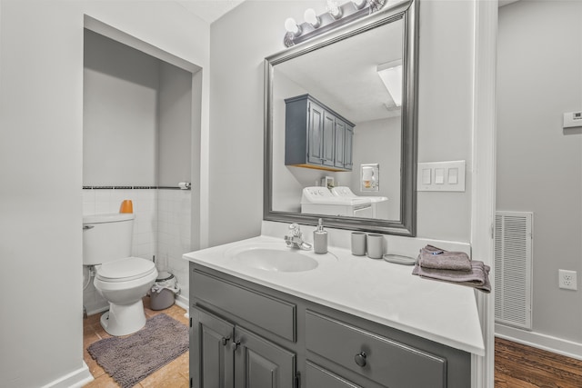 bathroom with tile walls, toilet, vanity, and wood-type flooring