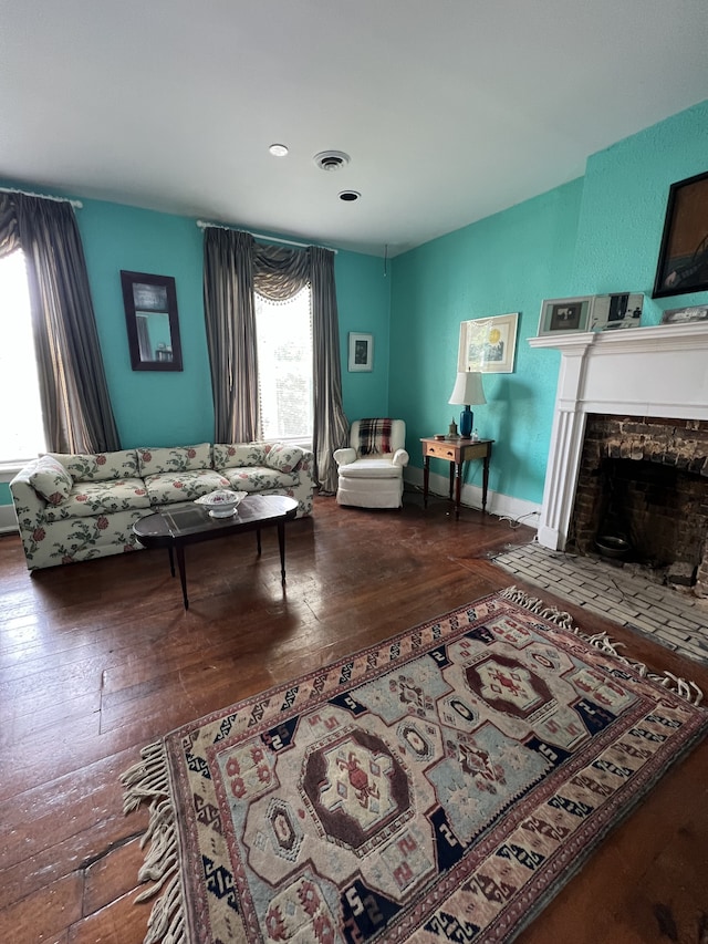 living room featuring a stone fireplace and hardwood / wood-style floors