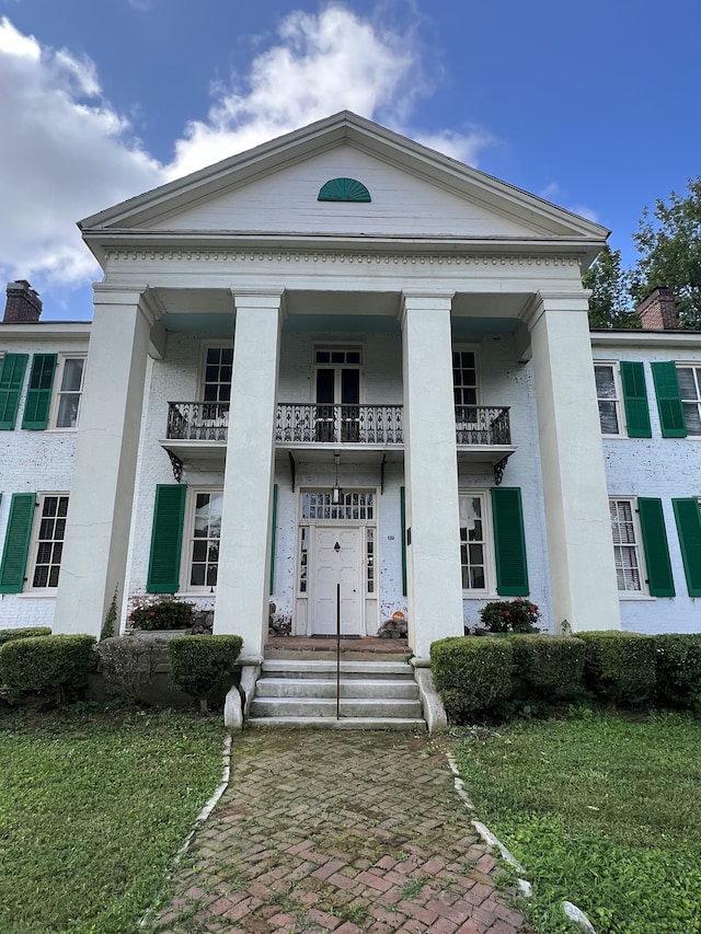 view of front of home featuring a front lawn and a balcony