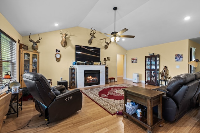 living room featuring ceiling fan, lofted ceiling, and light hardwood / wood-style flooring