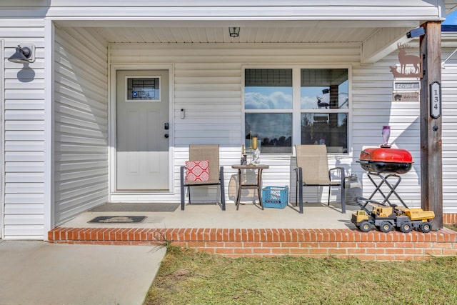 view of exterior entry featuring covered porch