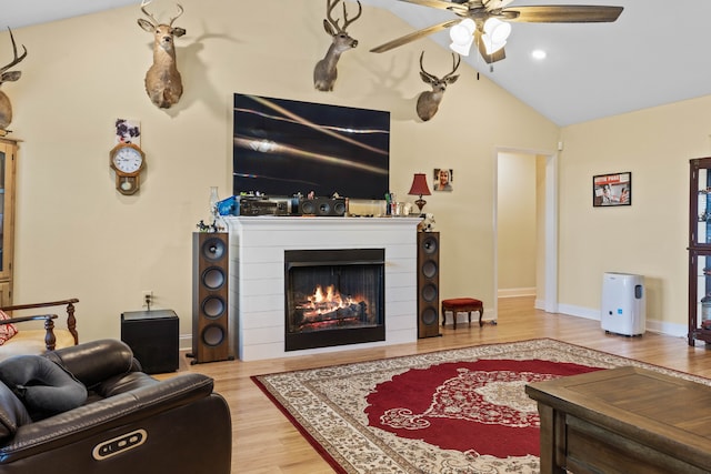 living room featuring high vaulted ceiling, light hardwood / wood-style floors, and ceiling fan