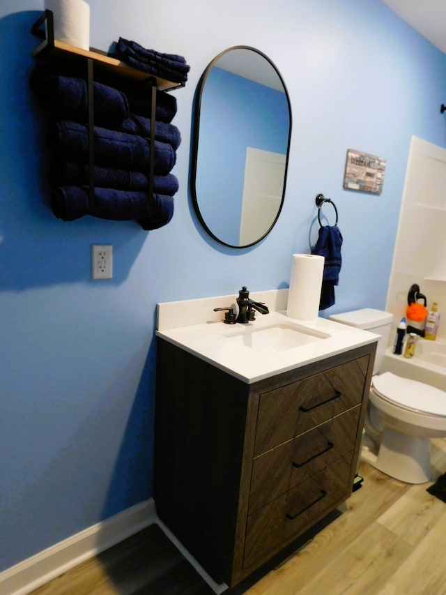 bathroom featuring hardwood / wood-style floors, toilet, and large vanity