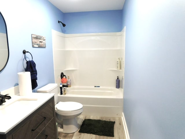 full bathroom with hardwood / wood-style flooring, toilet, washtub / shower combination, and vanity