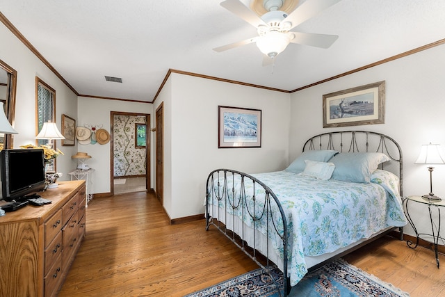 bedroom with ceiling fan, ornamental molding, and hardwood / wood-style flooring