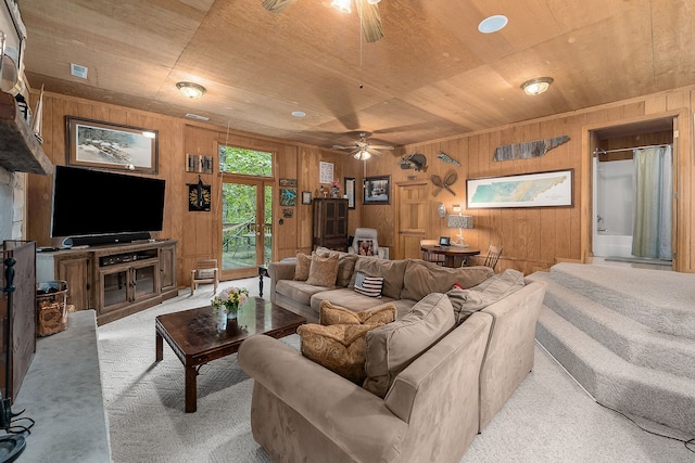 living room with wood ceiling, ceiling fan, light colored carpet, and wood walls