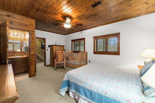 bedroom featuring ceiling fan, sink, light colored carpet, ensuite bath, and wooden ceiling