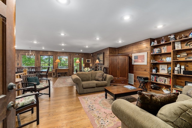 living room with wooden walls and light hardwood / wood-style flooring