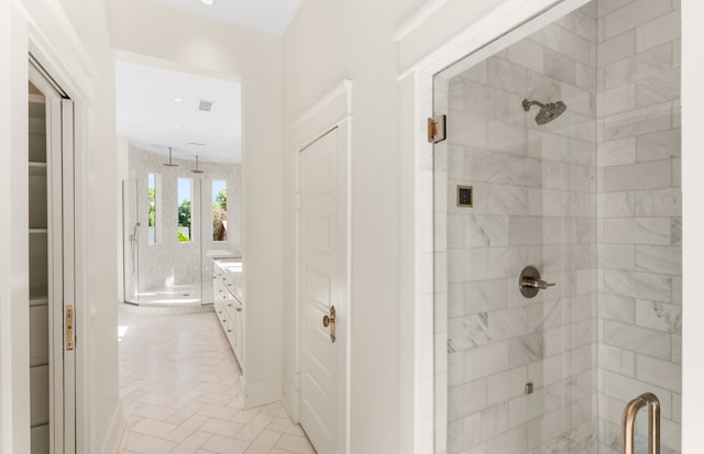 bathroom with tile floors, a shower with shower door, and vanity