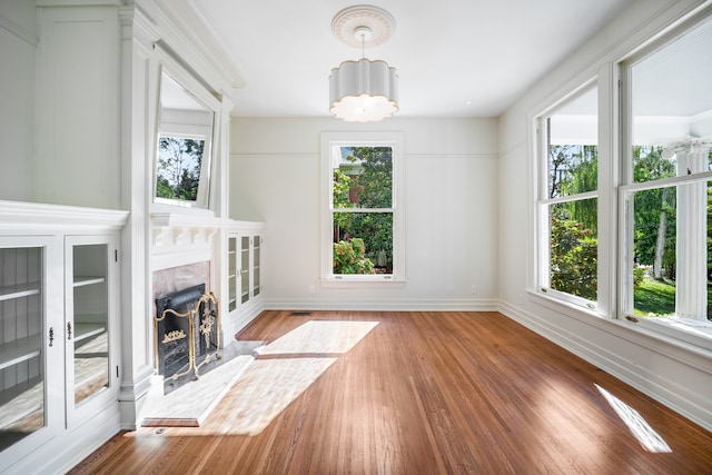 interior space with a notable chandelier, crown molding, dark wood-type flooring, and a fireplace