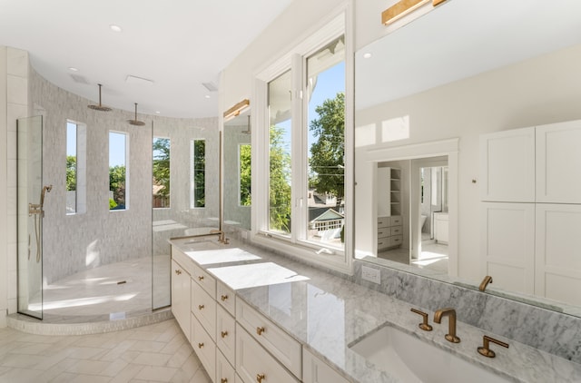 bathroom with double vanity, a shower with shower door, and tile flooring