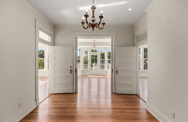 interior space with crown molding, light hardwood / wood-style floors, and a chandelier