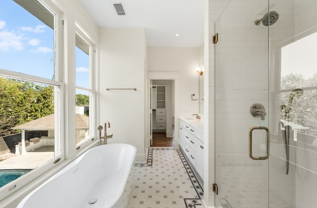 bathroom with vanity, plus walk in shower, and tile floors