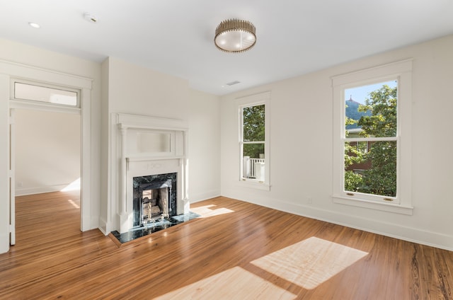 unfurnished living room featuring a fireplace and light hardwood / wood-style flooring