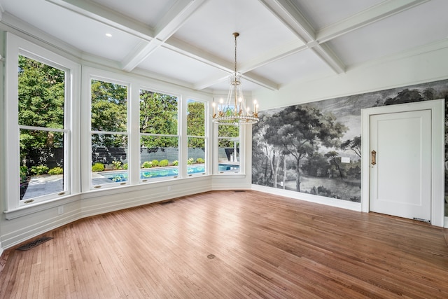 empty room featuring dark hardwood / wood-style flooring, a notable chandelier, and a wealth of natural light