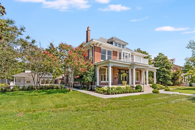 view of front of property with a balcony and a front yard