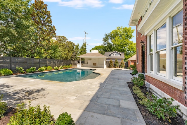 view of swimming pool featuring an outdoor structure and a patio