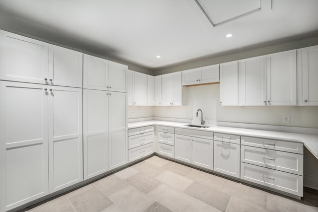 kitchen featuring white cabinets, light tile floors, and sink