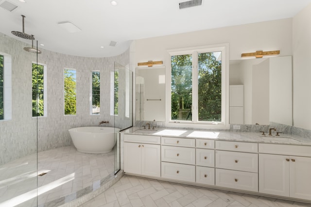 bathroom featuring shower with separate bathtub, tile walls, dual vanity, and tile floors