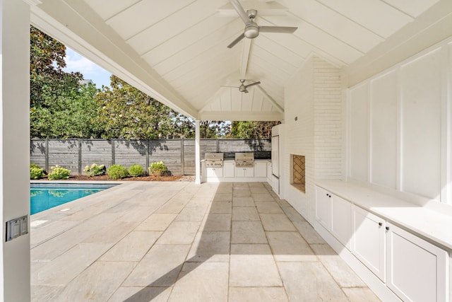 view of patio featuring ceiling fan, a fenced in pool, and an outdoor kitchen