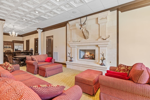 living room featuring crown molding, coffered ceiling, a chandelier, and a large fireplace