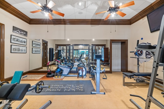 workout area featuring ceiling fan, light colored carpet, and ornamental molding