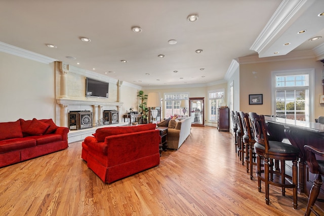 living room with light hardwood / wood-style flooring and ornamental molding